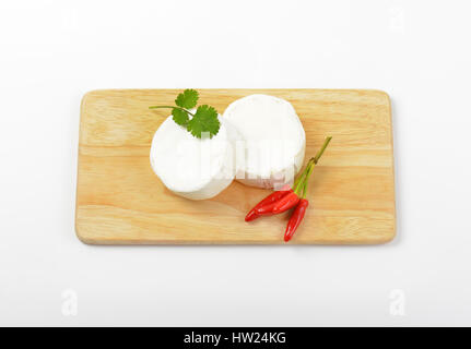 Roues de fromage blanc et de piment rouge on cutting board Banque D'Images