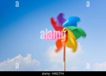 Motion blurred de moulinet multicolore contre fond de ciel bleu. Banque D'Images