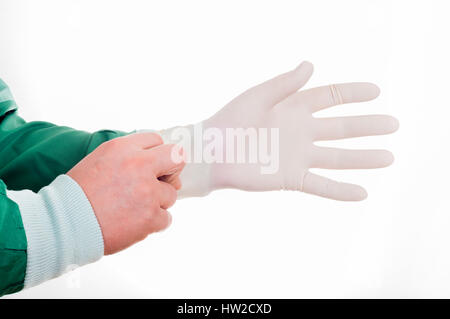 Close up of male doctor's mains mettre des gants chirurgicaux stériles sur contre fond blanc Banque D'Images