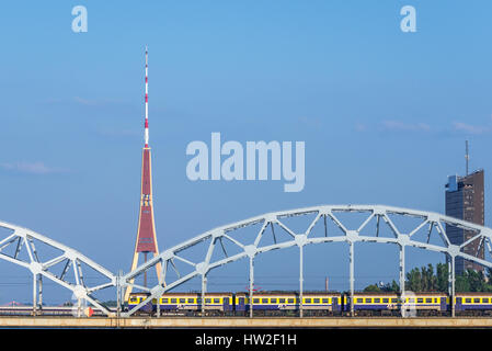 Pont ferroviaire sur la rivière Daugava (Dvina occidentale) à Riga, capitale de Lettonie. Vue du pont de pierre avec la radio et la tour de télévision sur le fond Banque D'Images