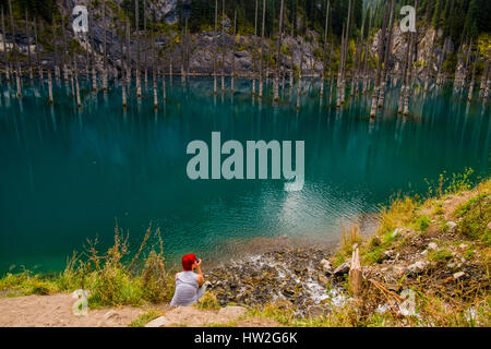 Caucasian woman photographing arbres dans le lac Banque D'Images