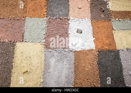 La texture de différentes couleurs d'argile sèche avec des pierres Banque D'Images