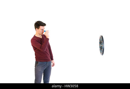 Adolescent homme portant un chandail hits quand jouer aux fléchettes isolé sur fond blanc Banque D'Images