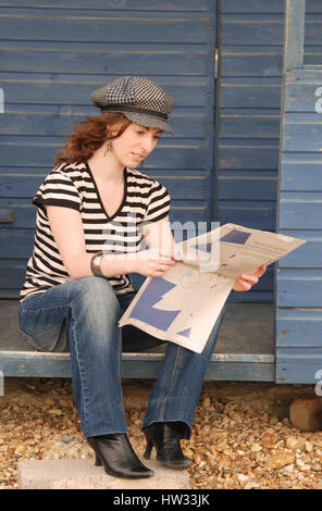 Belle brune jeune femme en jeans et t-shirt à rayures portant une casquette Banque D'Images