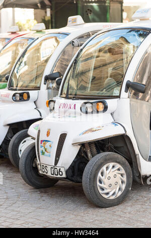 Les cabines électriques ou les taxis garés en attente de passagers dans la ville de La Valette Malte. Solutions de transport vert dans une ville. La Valette est la ville européenne o Banque D'Images