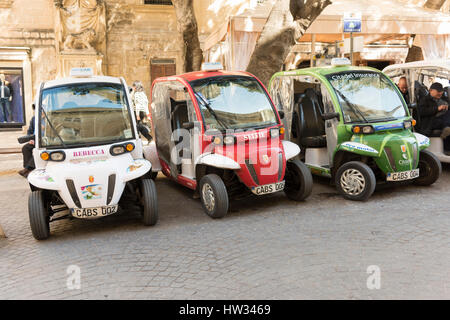 Les cabines électriques ou les taxis garés en attente de passagers dans la ville de La Valette Malte. Solutions de transport vert dans une ville. La Valette est la ville européenne o Banque D'Images