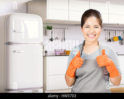 Femme au foyer asiatiques portant des gants de caoutchouc Thumbs up Banque D'Images