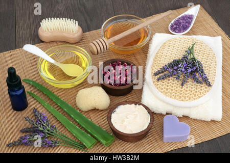 Soin à base de plantes ingrédients pour apaiser les problèmes de peau avec des fleurs de lavande, aloe vera et pétales de rose sur fond de bois de chêne sur le bambou. Banque D'Images