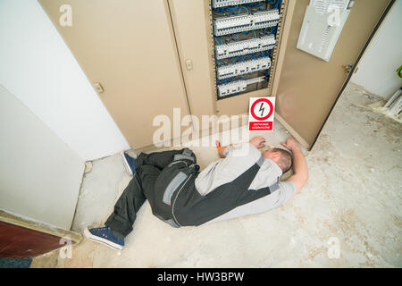 Électricien électrocuté gisant sur le sol Banque D'Images