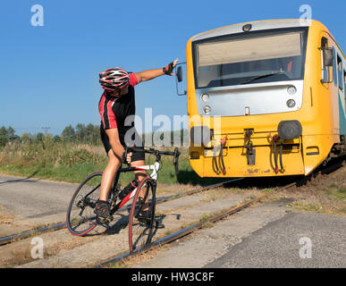 Cycliste malheureux a du mal sur le passage à niveau à laquelle le train s'approche. Le train passe au cycliste coincé dans les voies. Accident sur liaisons ferroviaires Banque D'Images