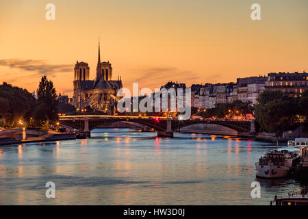 La Cathédrale Notre Dame de Paris, l'Ile Saint Louis et la Seine au coucher du soleil. Soirée d'été avec le pont Sully et les lumières de la ville à Paris Banque D'Images