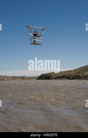 Technicien hydrologique du débit des mesures de panier suspendues sur la rivière Missouri. Calcul de débit vérifier station 'gabarit au mesures de hauteur. Banque D'Images