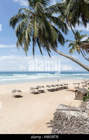 Peu de cabines privées pour fournir de l'ombre sur la plage de sable blanc à Kabalana, Ahangama, Sri Lanka Banque D'Images