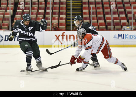 Detroit, Michigan, USA. Mar 16, 2017. Michigan State Spartans Sam Saliba F (10) coups de pied à la rondelle et son bâton brisé alors que Ohio State Buckeyes David Gust F (17) et Michigan State Spartans Mitch Eliot D (52) jouer sur pendant le match de hockey NCAA dans la grande finale du tournoi 10 entre Michigan State Spartans et Ohio State Buckeyes au Joe Louis Arena de Détroit (Michigan). Allan Dranberg/CSM/Alamy Live News Banque D'Images