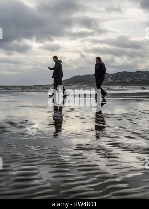 Charmouth plage, Charmouth, Dorset, UK. 17 mars 2017. Un couple se présente pour une promenade sur un gris et couvert l'après-midi à Charmouth plage. © Dan Tucker/Alamy Live News Banque D'Images