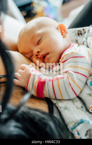 Mother holding sleeping baby daughter Banque D'Images