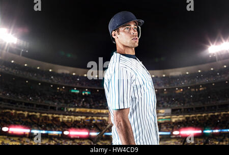 Mixed Race baseball player standing in stadium Banque D'Images