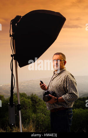 Assistant Photographe mesurant la lumière dans une séance photo en plein air au coucher du soleil Banque D'Images