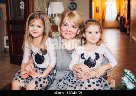 Grand-mère de deux petites-filles sourire pour la caméra Banque D'Images