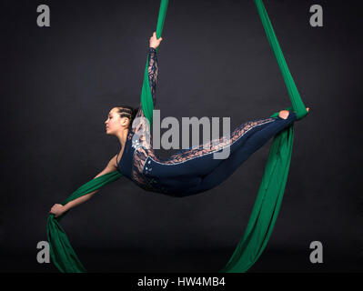 acrobaties aériennes de la femme dans les peintures - fond sombre. Photographie de studio d'artistes de cirque Banque D'Images