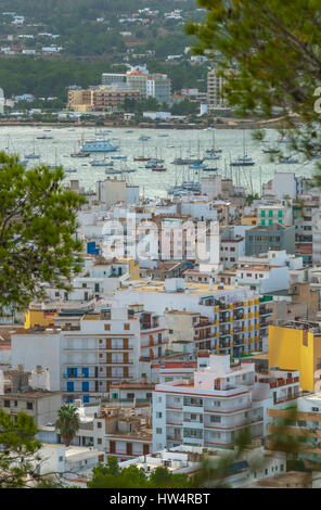 Voir l'ossature à travers naturellement les arbres, à partir de la colline de la ville à proximité : San Antonio Sant Antoni de Portmany dans les îles Baléares, Ibiza, Espagne. Banque D'Images