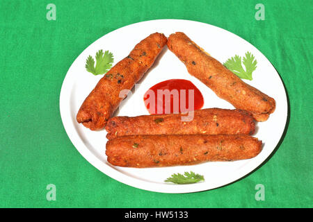 Veg seekh kabab mis en plaque blanche sur fond vert Banque D'Images