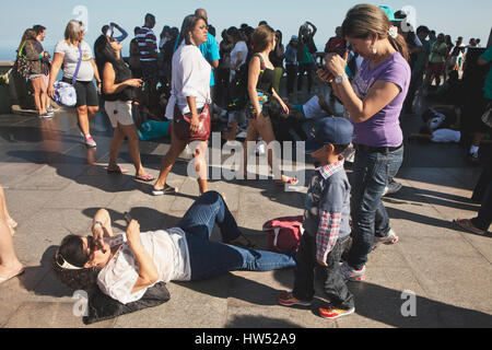 Les touristes sont couchées sur le sol pour prendre des photos de la statue du Christ Rédempteur aussi connu comme le Christ Rédempteur à Rio de Janeiro, Brésil. La Statue Banque D'Images