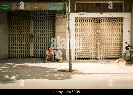 Ho Chi Minh Ville, Vietnam - Mars 29, 2014 : les hommes vietnamiens se reposant à l'ombre sur la rue de Ho Chi Minh Ville, Vietnam le 29 mars 2014. Banque D'Images