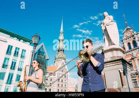 Riga, Lettonie - 1 juillet 2016 : Street Music Trio Groupe de trois jeunes musiciens gars jouant les instruments pour le don sur la place de l'hôtel de ville, célèbre Banque D'Images