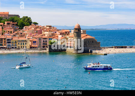 Bateau de tourisme arrive dans la vieille ville de Collioure au-delà de l'église Notre Dame des Anges, la Côte Vermeille, France Banque D'Images