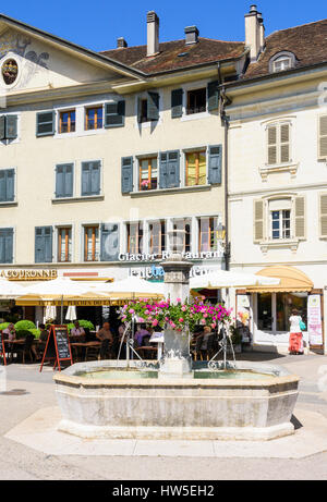 Cafés et restaurants derrière une fontaine dans la vieille ville de Nyon, Suisse Banque D'Images