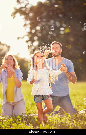 Fun pour enfant de sexe féminin avec des bulles de savon outdoor Banque D'Images