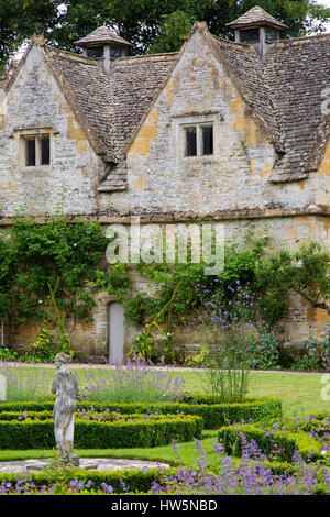 Statue de jardin et de fleurs à Lower Slaughter Manor House, Lower Slaughter, les Cotswolds, Gloucestershire, England, UK Banque D'Images