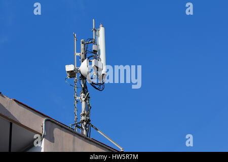 L'antenne mobile dans le toit d'un immeuble, contre le ciel bleu Banque D'Images