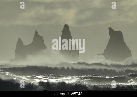 Les piles de la mer de Reynisdrangar, Islande vagues se brisant sur Renisfjara plage en face de l'basaltiques de Reynisdrangar, le sud de l'Islande Banque D'Images