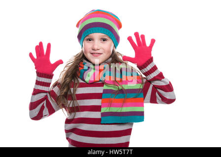 Smiling pretty little girl wearing colorful en écharpe, chapeau et des gants isolé sur fond blanc. Les vêtements d'hiver Banque D'Images