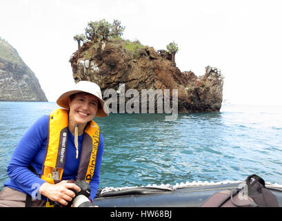 Une femelle solo traveler sourires sur un panga en barque dans Buccaneer Cove à l'extérieur de l'île de Santiago dans les Galapagos. Banque D'Images