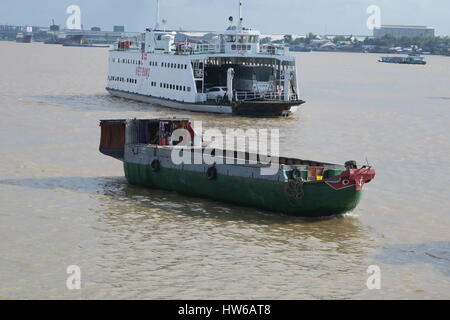 Mékong en Indochine, il vous suffit de bateau en bois sur la rivière sale avec des maisons sur des piliers colorés voile unique. Banque D'Images