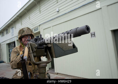 Soldat américain WW2 Reinactor avec la mitrailleuse Bren pointant à l'appareil photo dans le port de Portsmouth Banque D'Images