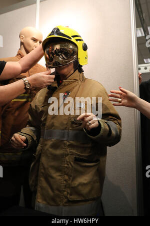 Premier ministre écossais Nicola Sturgeon essaie sur une tenue que les pompiers elle tours les étals au printemps SNP Conférence à l'AECC à Aberdeen. Banque D'Images