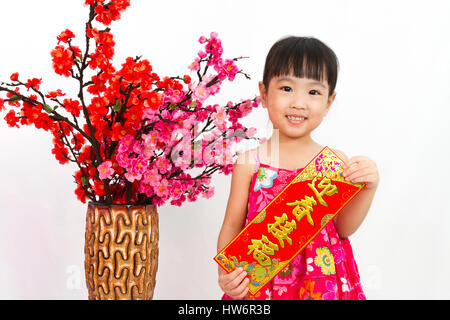 Chinese little girl holding Spring Festival couplets salutations pour le Nouvel An chinois à fond blanc isolé. Banque D'Images