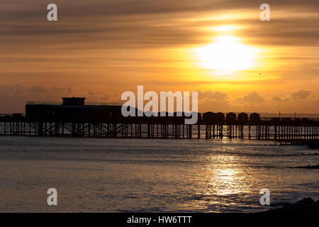 Un spectaculaire coucher du soleil doré illumine le ciel au-dessus de la jetée de Hastings, Royaume-Uni Banque D'Images