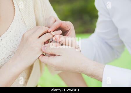L'offre de se marier. mains de l'homme s'habiller un anneau sur l'belo Banque D'Images