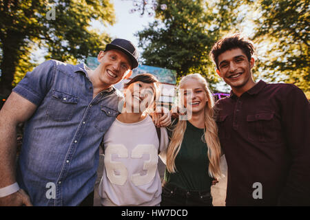 Amis multiraciale unis dans le parc d'attractions. Groupe d'amis dans un parc d'attractions à la caméra et au sourire. Banque D'Images