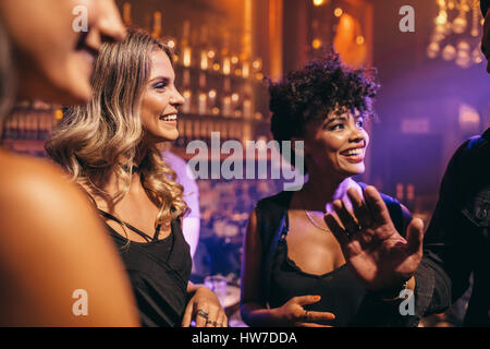 Groupe de jeunes bénéficiant d'une nuit d'amis au pub. Les jeunes s'amusant à la discothèque. Banque D'Images