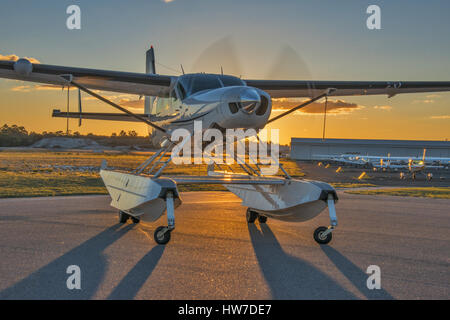 Float Cessna 208 Caravan équipé avec le moteur en marche, rétroéclairé par le soleil couchant Banque D'Images