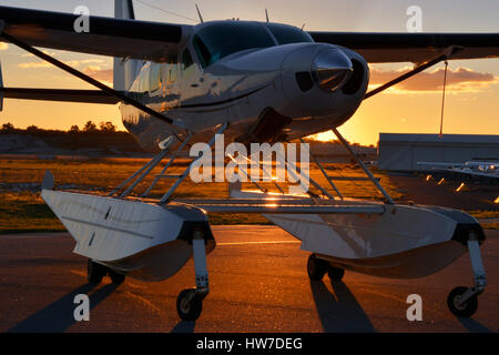 Float Cessna 208 Caravan équipé avec le moteur en marche, rétroéclairé par le soleil couchant Banque D'Images