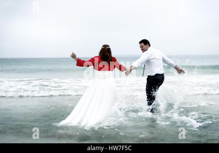 Couple marié jouant dans l'eau de mer Banque D'Images