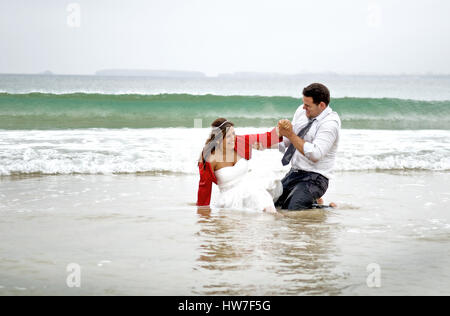 Couple marié jouant dans l'eau de mer Banque D'Images