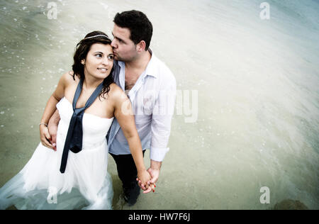 Couple marié jouant dans l'eau de mer Banque D'Images